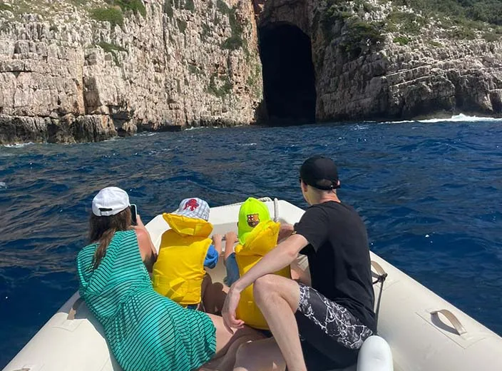 A family on a boat trip Vlore, going inside Haxhi Ali Cave.