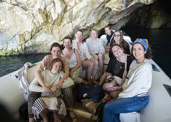 A group of girls, taking a photo in the entrance of Dafina cave, during a boat trip Vlore, Albania